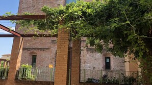 Un edificio in mattoni con una grande finestra ad arco centrale e una più piccola finestra sopra.