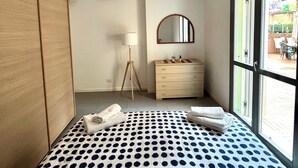 Una camera da letto con un letto, una cassettiera, uno specchio e una finestra.