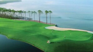 A golf course with sand bunkers, a water body, and a line of trees. - Bliss: Gated! Pool! Free Golf Cart! Sleeps 20! (Miramar Beach)