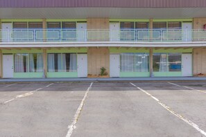 A motel with a two-story structure, numbered rooms, a parking lot, and a small garden area. - Sonrise Inn Lincoln Hwy By OYO (Breezewood)
