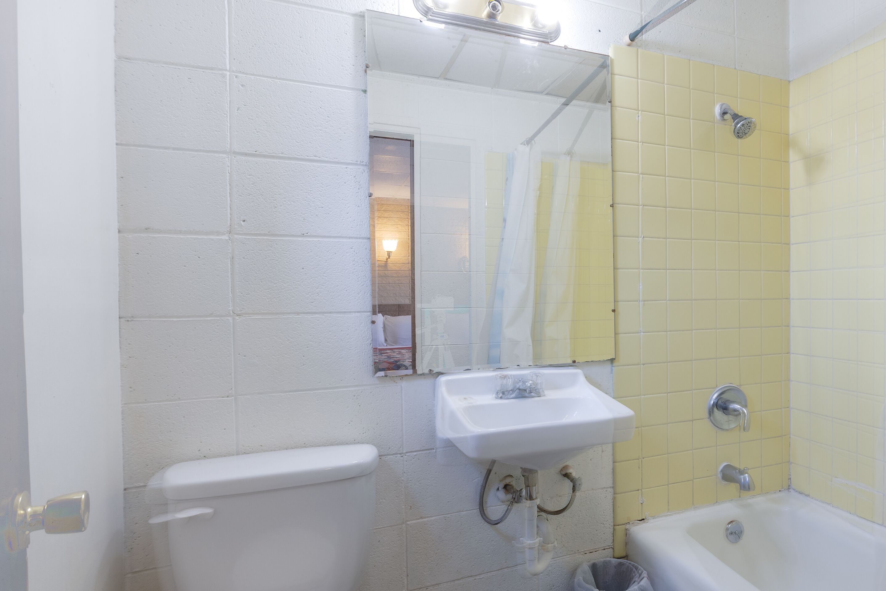 A bathroom with a white toilet, a sink, and a bathtub.