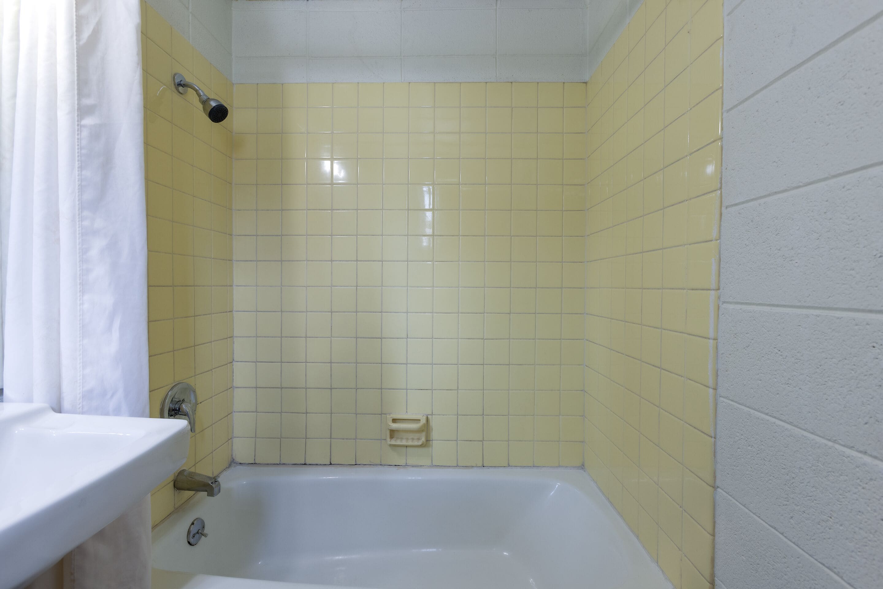 A bathroom with a bathtub, a sink, and a showerhead.