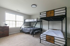 A room with bunk beds, a dresser, and a window. - Sleeps 14 on a Duck River ranch: 4 en suite bedrooms, patio, fishing, horses (Normandy)