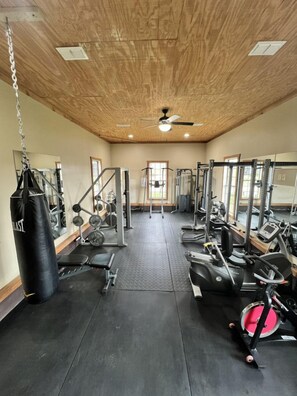 A gym with various exercise equipment, a punching bag, and a ceiling fan. - Lakeview house on a 180-acre Duck River ranch: fishing, horses, bonfires (Normandy)