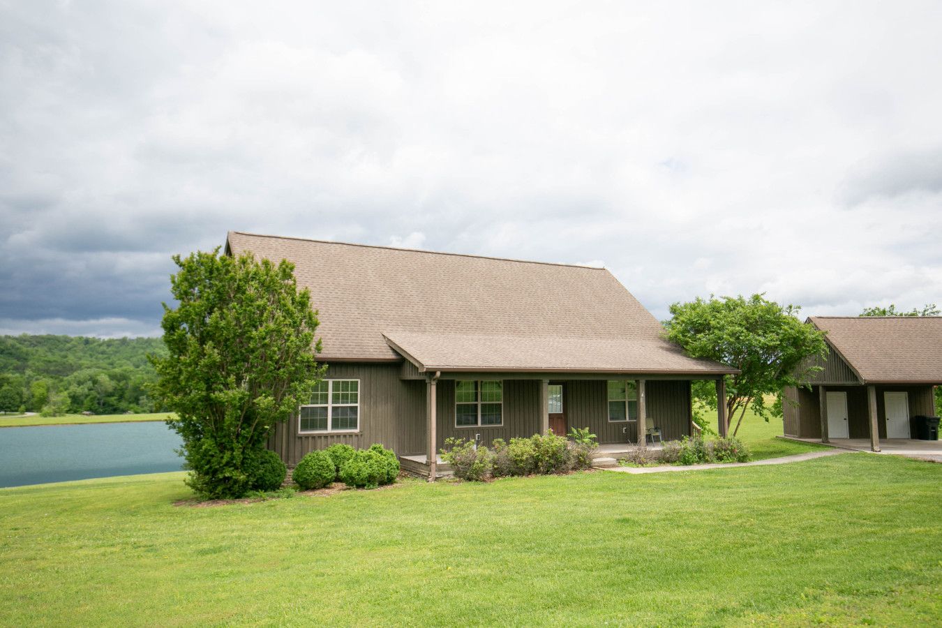 A two-story building with a flat roof, a covered porch, and a small attached garage.