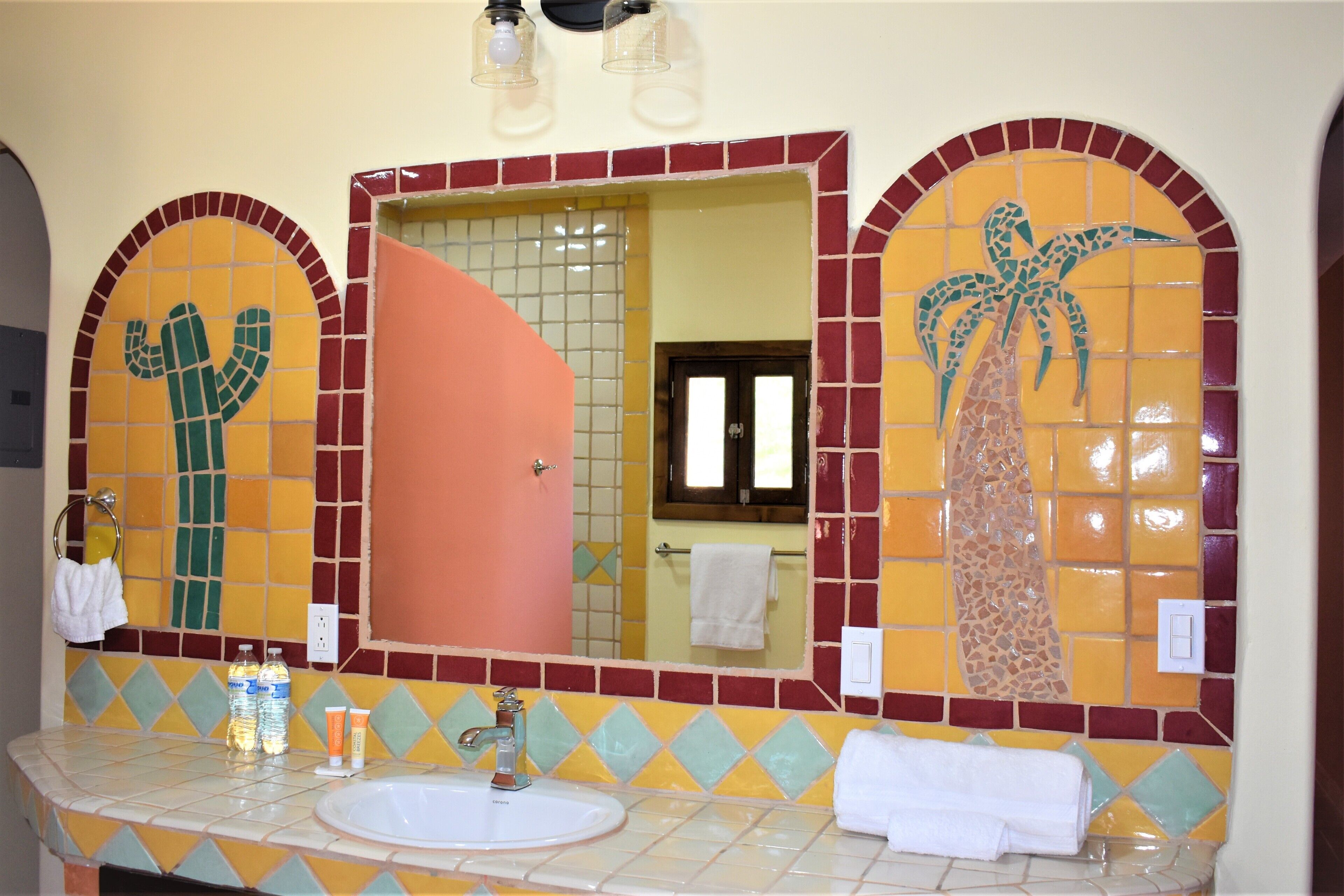 Une salle de bain avec un lavabo, deux flacons de lotion, un miroir et un porte-serviettes.