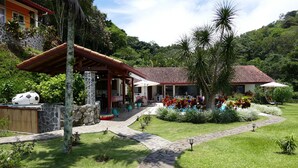 A tropical resort with a stone pathway, outdoor seating, and lush landscaping. - BUNGALOWS SANLAZ (Jesús)