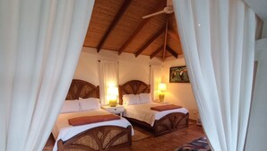 A cozy room with two beds, a bench, and a ceiling fan. - BUNGALOWS SANLAZ (Jesús)