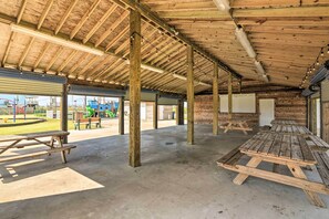 Enjoy outdoor dining under a rustic ceiling with picnic tables and a playground nearby.