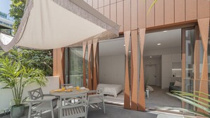 A modern outdoor patio with a table and chairs, surrounded by potted plants and a large umbrella. - In the city centre - Cine Park Residence I (Funchal)
