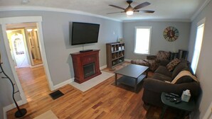 A living room with a fireplace, a television, a sofa, and a coffee table.