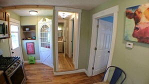 A compact kitchen with a stove, a refrigerator, and a dining area with a chair.