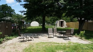 An outdoor patio area with a table and chairs, surrounded by a wooden fence and trees. - Harper, Two Bedroom House in Historic Loveland (Loveland)