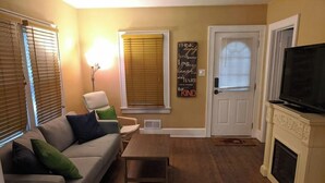 A living room with a sofa, a coffee table, a fireplace, and a television. - Ohio Ave, 3 bed house, Historic Downtown Loveland (Loveland)