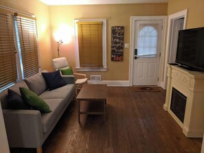 A living room with a sofa, a coffee table, a fireplace, and a television. - Ohio Ave, 3 bed house, Historic Downtown Loveland (Loveland)