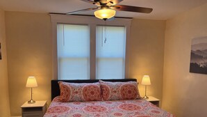 A bedroom with a bed, two bedside lamps, a ceiling fan, and two windows with blinds. - Ridgeway, 2 Bedroom House near Xavier, Downtown (Cincinnati)