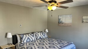 A bedroom with a bed, nightstands, a ceiling fan, and wall art. - Carter #4, Two bedroom unit near Xavier, Downtown (Cincinnati)