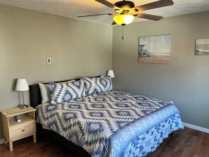 A bedroom with a bed, nightstands, a ceiling fan, and wall art. - Carter #4, Two bedroom unit near Xavier, Downtown (Cincinnati)