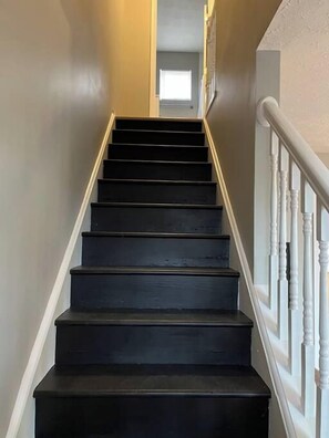 A staircase with black steps and white balusters.
