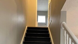 A staircase with black steps and white balusters. - Carter #4, Two bedroom unit near Xavier, Downtown (Cincinnati)