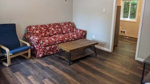 A room with a red floral sofa, a blue chair, and a wooden coffee table. - Carter #5, Private Two Bed near Xavier, Downtown (Cincinnati)