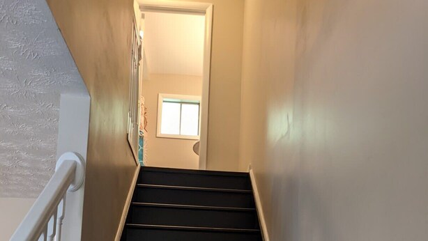 A staircase with white railings and dark steps leading to a door. - Carter #5, Private Two Bed near Xavier, Downtown (Cincinnati)
