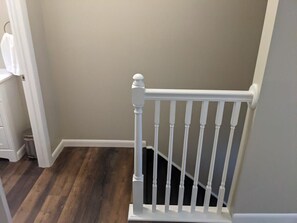 A staircase with a white railing and a dark wooden floor. - Carter #5, Private Two Bed near Xavier, Downtown (Cincinnati)