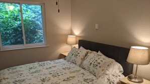 A bedroom with a bed, two bedside tables, a window, and a lamp. - Carter #5, Private Two Bed near Xavier, Downtown (Cincinnati)