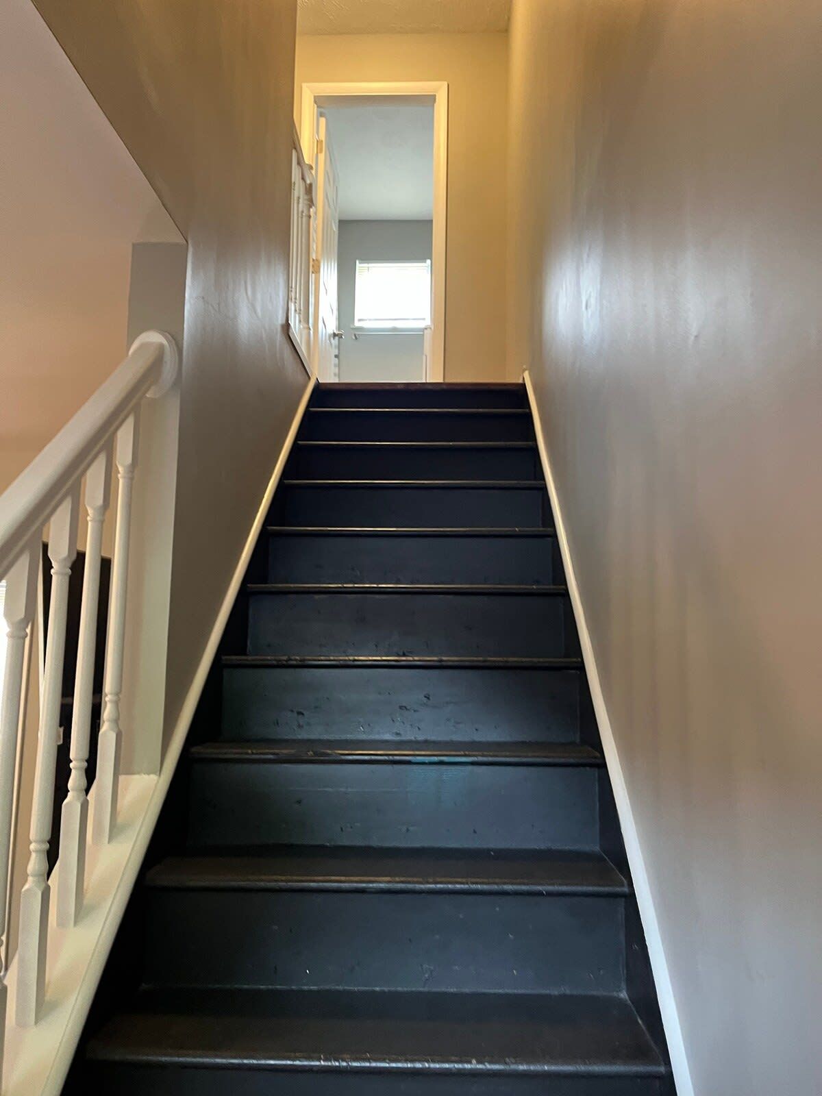 A staircase with a handrail leading to an interior space.