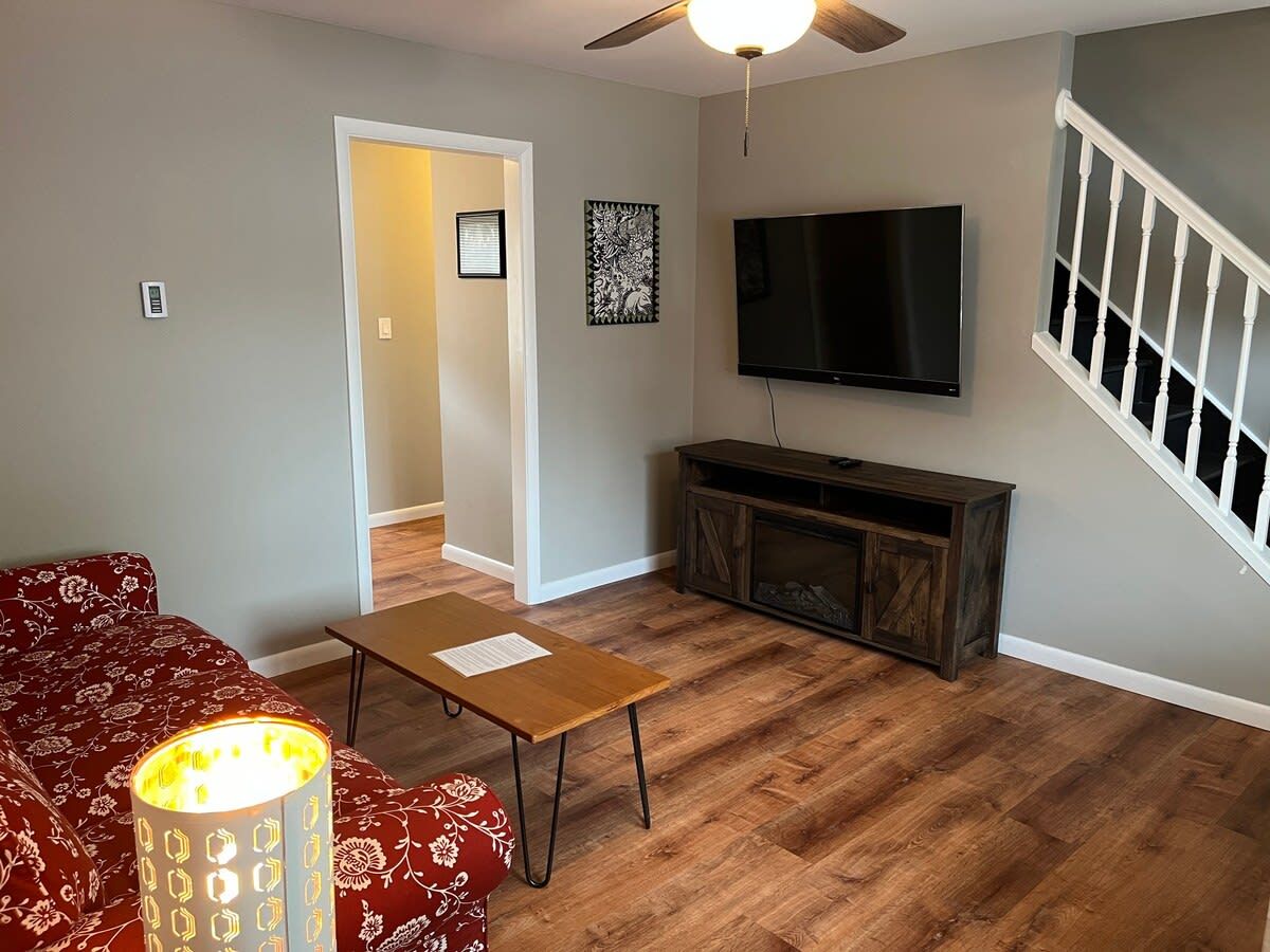 A living room with a sofa, coffee table, TV, and entertainment unit.