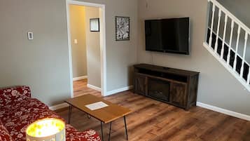 A living room with a sofa, coffee table, TV, and entertainment unit.