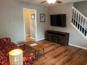 A living room with a sofa, coffee table, TV, and entertainment unit.