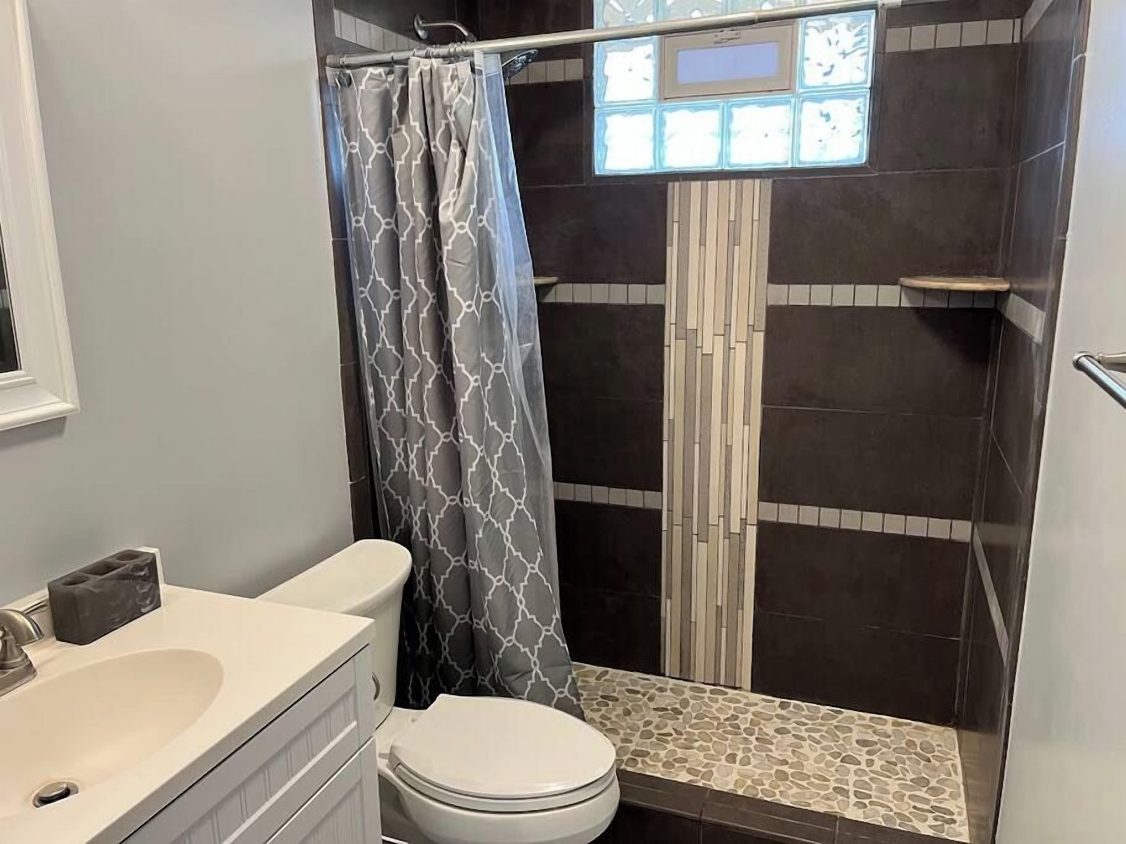 Une salle de bain comprenant des toilettes, un lavabo et un espace douche.