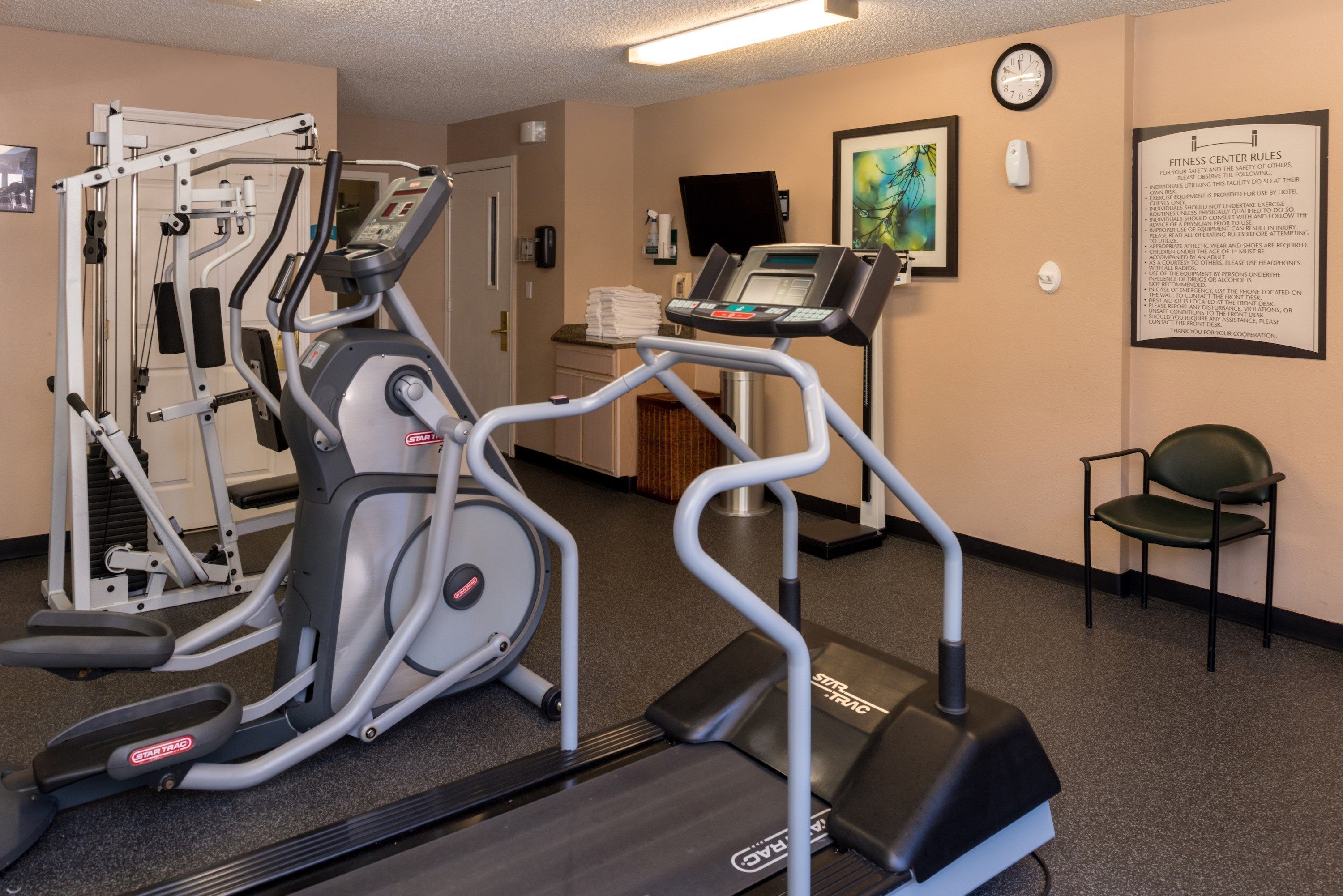 A fitness center with cardio machines, a weight bench, and a treadmill.