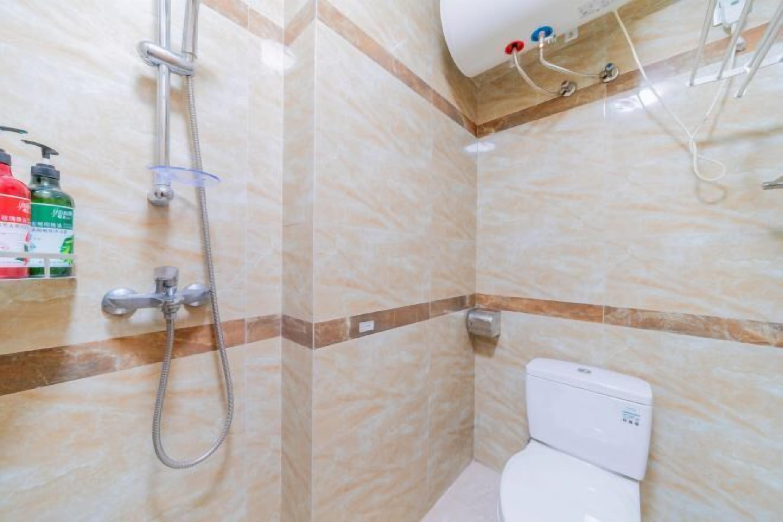 Un baño con ducha, inodoro y un estante con artículos de aseo.