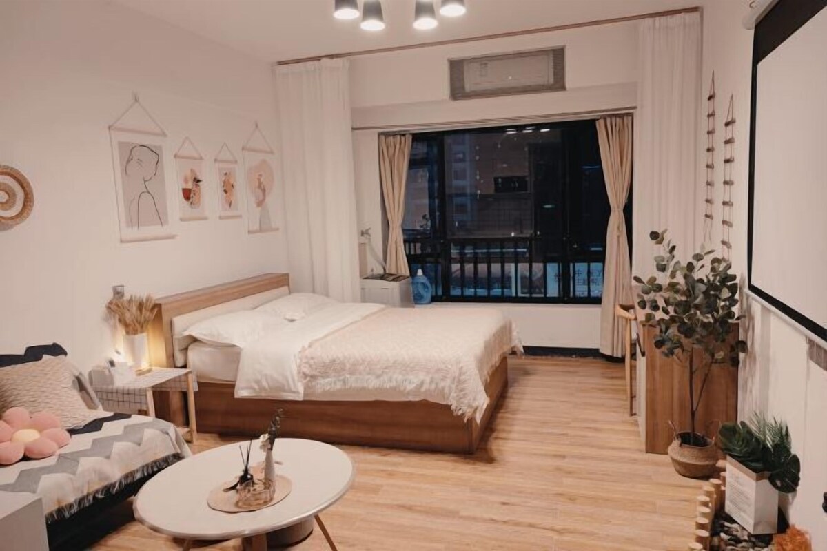 A modern bedroom with a bed, bedside table, and a round coffee table.