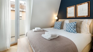 A hotel room with a bed, a large window, and a view of a building outside. - GuestReady - Modern and exquisite apt near Estrela (Lisbon)