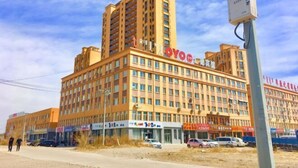 A multi-story hotel with a prominent 'OYO' sign, featuring a modern architectural design with a flat roof and numerous windows. - OYO Ulanhot Huide Business Hotel (Ulanhot)