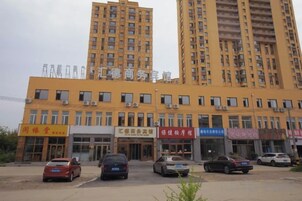 Un edificio de varios pisos con varios locales comerciales en la planta baja.