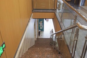 A staircase with metal railings and a wooden wall. - OYO Ulanhot Huide Business Hotel (Ulanhot)
