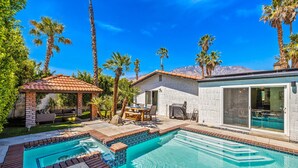 A backyard with a swimming pool, patio furniture, and a covered seating area. - Chic Spanish Palm Springs ~2000 square feet Pool Home (Palm Springs)