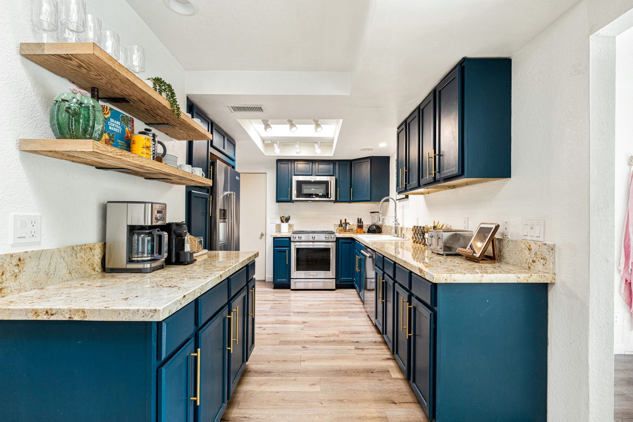 Une cuisine moderne avec des meubles de couleur bleu foncé, un îlot central et des appareils électroménagers intégrés.