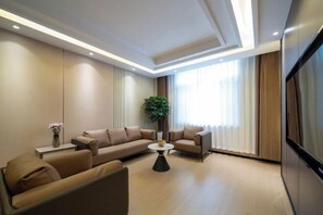 Un salon moderne avec un ensemble de canapés, une table basse et une plante en pot.