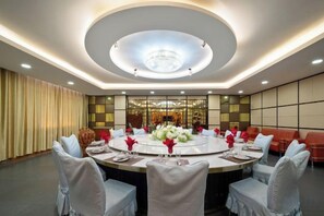 A conference room with a round table, chairs, and a chandelier. - Pegasus Hotel (Zhaosu)