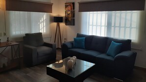 A living room with a sofa, armchair, coffee table, and a floor lamp. - La Villa Palmier Your quiet House (Puerto Vallarta)