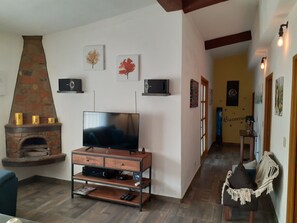 A living room with a fireplace, TV, and wooden entertainment unit.