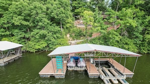 Un ponton flottant doté de sièges abrités et d’un espace couvert, entouré d’une forêt verdoyante et dense.