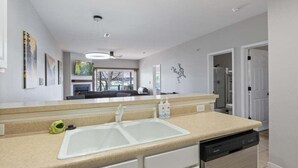 Una cocina moderna con un lavamanos blanco, lavavajillas y encimera.