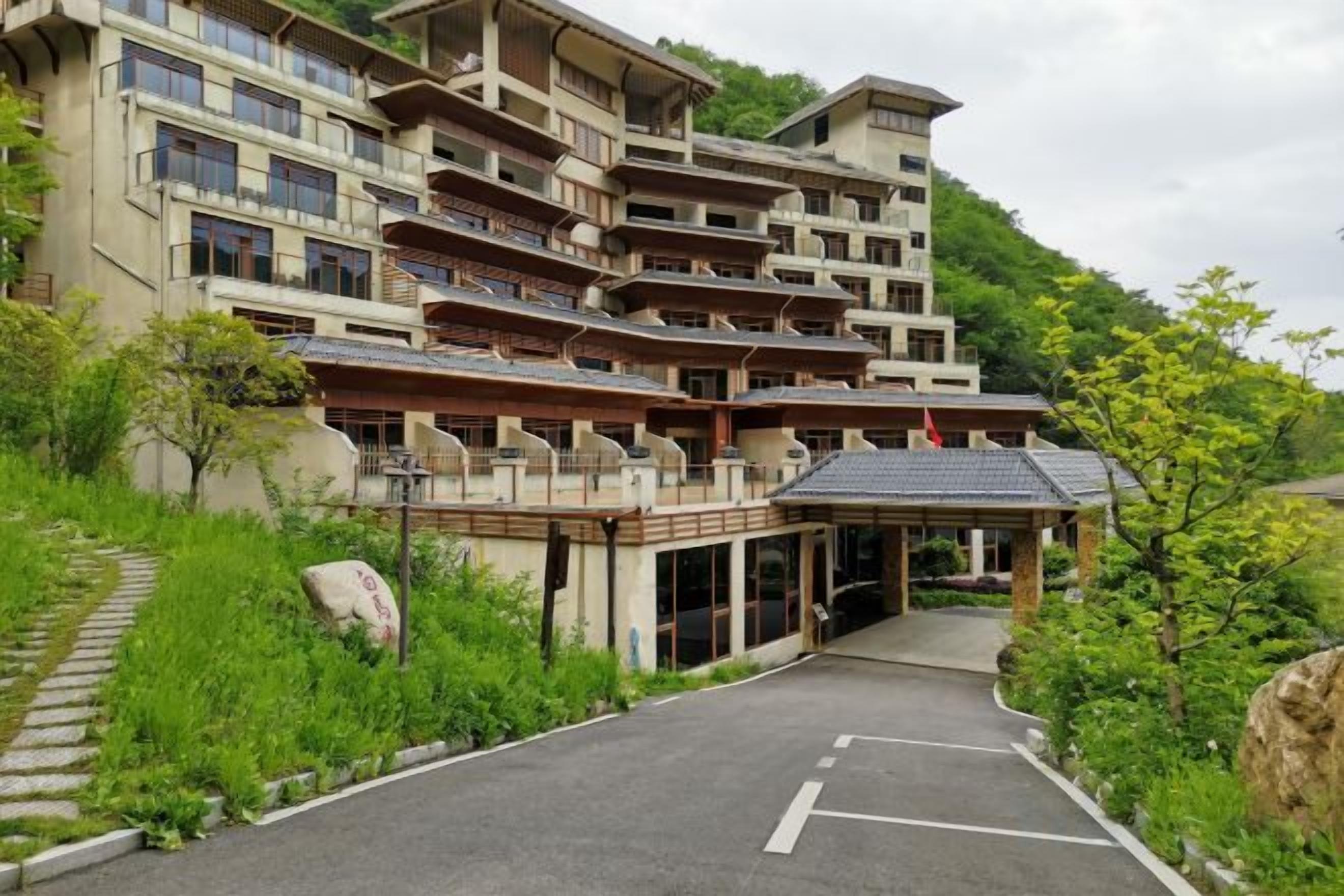 A multi-story hotel with a traditional architectural style, featuring balconies and a covered entrance.