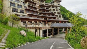 Um hotel de vários andares com estilo arquitetônico tradicional, com varandas e entrada coberta.